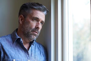 Generalisierte Ängste loswerden Ein Mann schaut aus dem Fenster. Er ist ohnmächtig, da seine Angst zu groß ist, um nach draußen zu gehen. Mit Hypnose kann er seine generalisierte Angststörung loswerden.