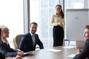 Ohne Vortragsangst vor Gruppen stehen und seine Ideen präsentieren. Eine Frau steht vor einer Businessgruppe und präsentiert ihre Ideen.