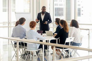 Ohne Vortragsangst vor Gruppen stehen und seine Ideen präsentieren. Ein Mann steht vor einer Businessgruppe und präsentiert seine Ideen.